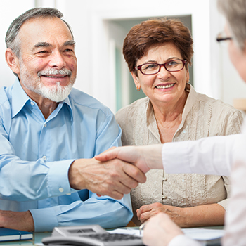 A man and woman engaged in a handshake,