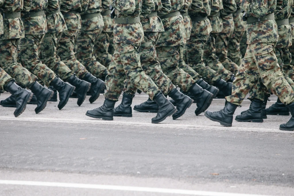 A group of soldiers in camouflage uniforms marching in formation.